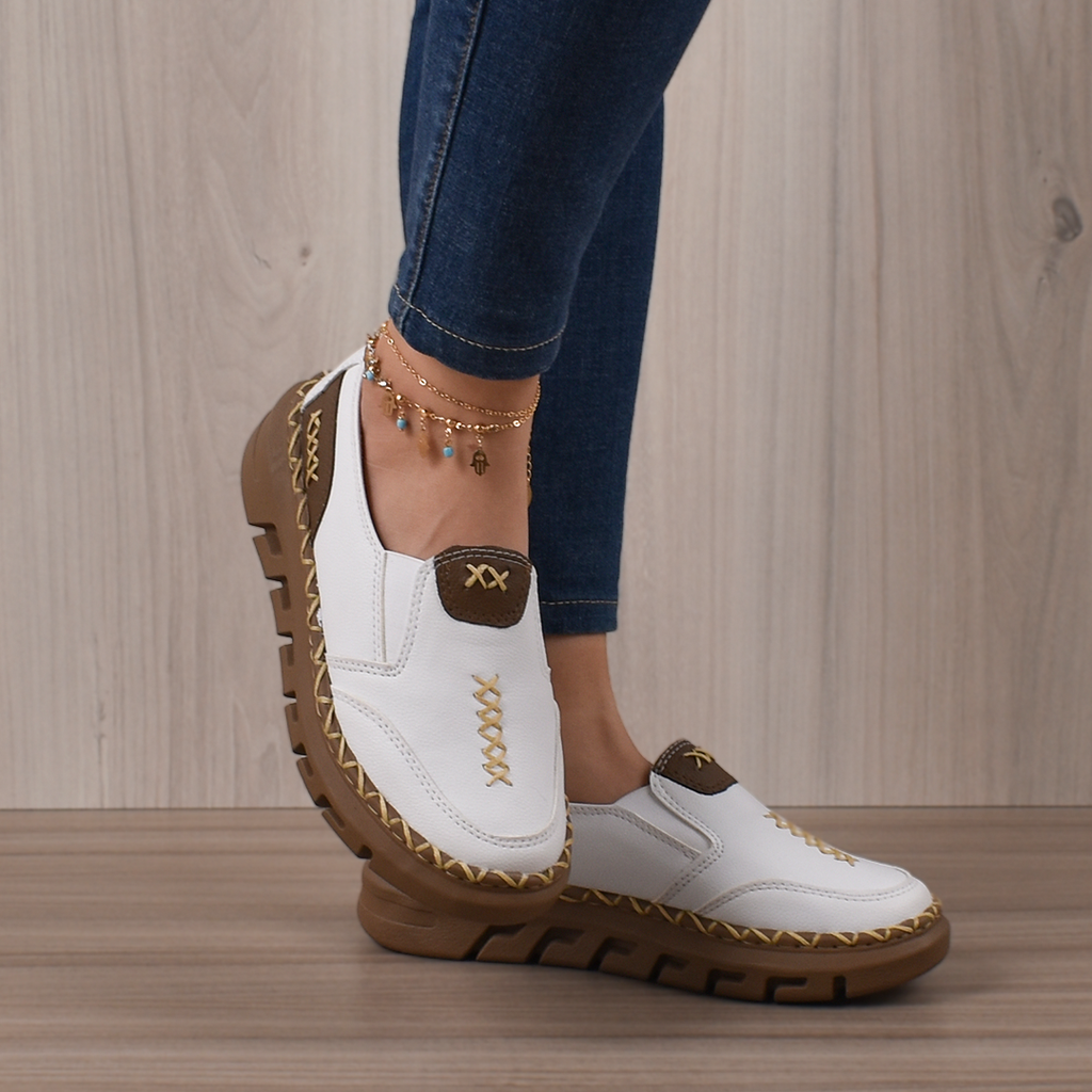 Mocasines Bellami blancos de cuero, con costuras decorativas doradas, detalle marrón en el empeine y suela gruesa.